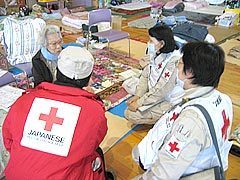 午前10時から巡回診療開始。体育館内フロアにおいて、心のケアを行う斎賀医師、佐藤看護師長、山辺医療社会事業課長の様子