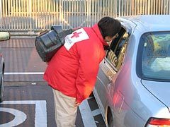 午前6時30分、車中泊をしている被災者に肺塞栓症（エコノミークラス症候群）の予防と安全の確認のための巡回をする佐藤看護師長の様子