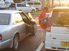 午前6時30分、車中泊をしている被災者に肺塞栓症（エコノミークラス症候群）の予防と安全の確認のための巡回をする佐藤看護師長の様子