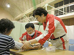 被災者の血圧を測る救護スタッフの様子